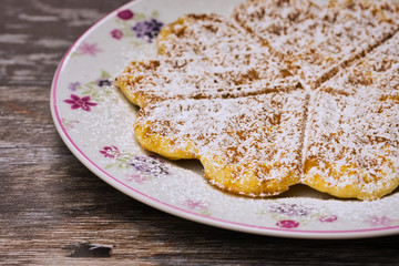 fresh baked waffle on a plate against wooden background
