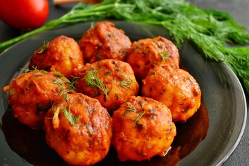 Meatballs in tomato sauce. Chicken meatballs. Meatballs in a pan on a dark table background isolated.