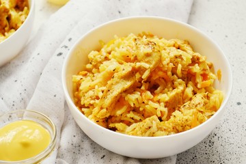 Rice in a white bowl. Rice dish on a white table background. Pilaf, rice porridge, cooked rice with vegetables. Healthy vegetarian food.