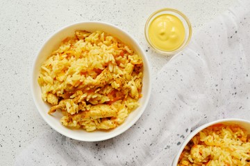 Rice in a white bowl. Rice dish on a white table background. Pilaf, rice porridge, cooked rice with vegetables. Healthy vegetarian food.