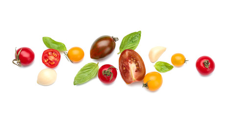 Different fresh tomatoes with garlic and basil on white background
