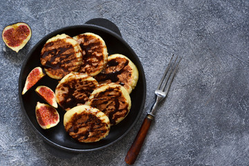 Cheesecakes with chocolate sauce in a pan on a concrete background