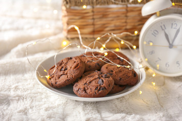 Plate with cookies and garland on plaid