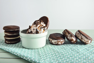 Bowl with tasty ice cream and chocolate cookies on table