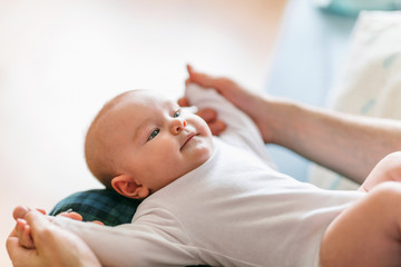 Satisfied kid in the arms of dad. Divide the responsibilities of caring for a child between spouses