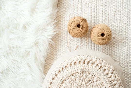 threads, crocheted round napkin. White napkin like a flower. on a fur white background and knitted light background. Balls of thread in a wicker box.cozy home and handmade concept