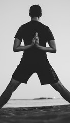 Silhouette of man doing yoga on the beach