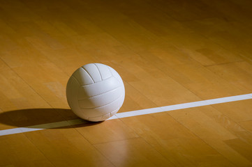 Volleyball court wooden floor with ball on black with copy-space