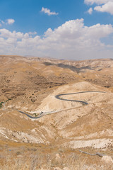 Empty road in a desolated dry desert mountain landscape with no trees in Palestine