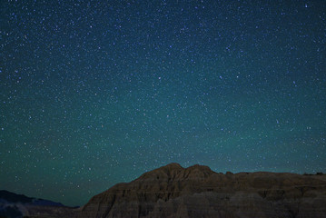A starry sky over a desert mountain