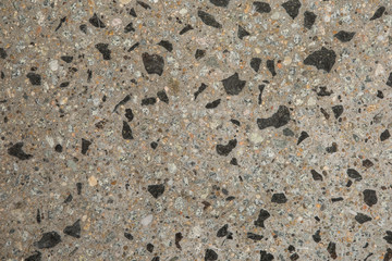 Gros plan texture béton désactivé avec graviers gris, noir et couleur