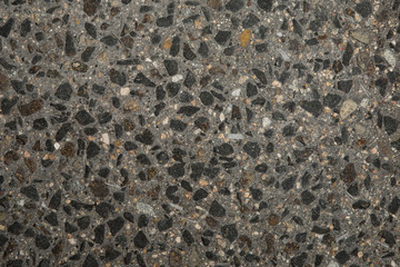 Gros plan texture béton désactivé avec graviers gris, noir et couleur