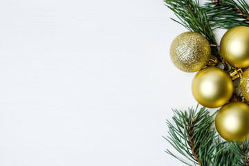 Different golden new year's balls on pine branches on background with copy space.