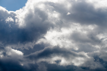 Blue sky with storm clouds, in the rays of sunlight.