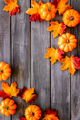 Autumn frame with colorful leaves and pumpkins on dark wooden top view copy space