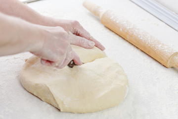 Woman's hands knead dough. Cooking pizza. Hands chef knead dough for pizza. Knead dough with your...