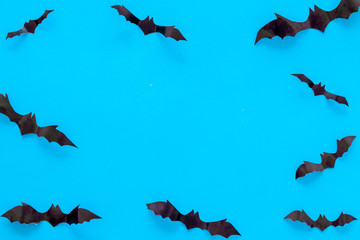 Bats cutout on Halloween frame on blue table top view copy space