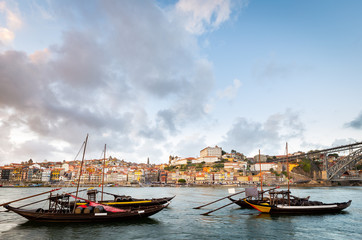 Fototapeta na wymiar City of Porto as seen from across the Douro River with historical boats (Rabelos)