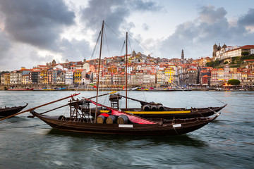 Fototapeta na wymiar City of Porto as seen from across the Douro River with historical boats (Rabelos)