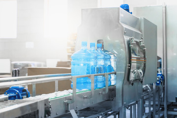Water bottling conveyor line with plastic bottles or gallons on water factory production