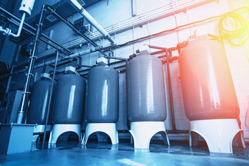 Large reservoirs and tanks and pipes in modern water production plant or factory. Industrial...