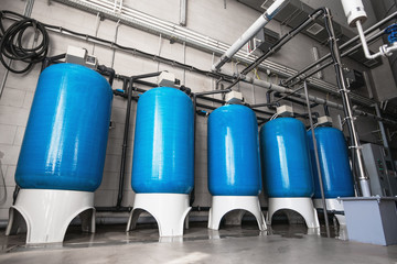 Drinking water factory or plant production, industrial interior. Large metal tanks for filtering...