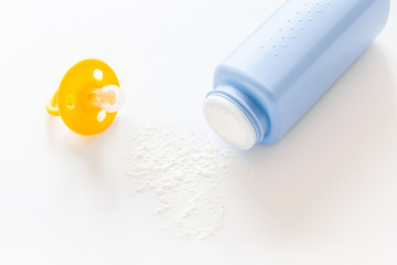 Baby talcum powder for delicate skin care near pacifier on white background