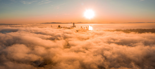 Beautiful cloudy morning in San Francisco, USA. Sunset over the clouds with skyscrapers rising...