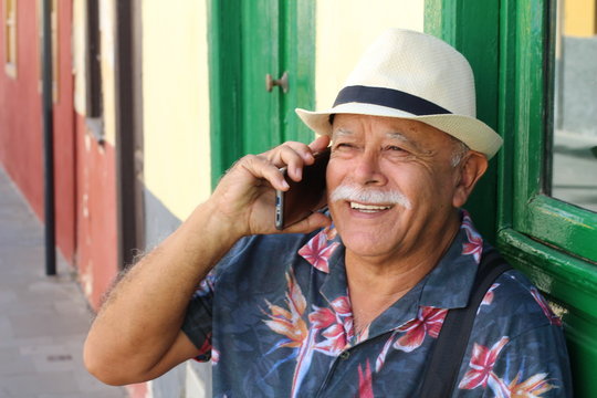 Senior Hispanic man using cellphone outdoors