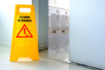 Caution wet floor label in toilet. cleaning toilet in office.