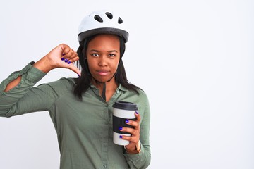 Young african american woman wearing bike helmet and drinking coffee over isolated background with angry face, negative sign showing dislike with thumbs down, rejection concept