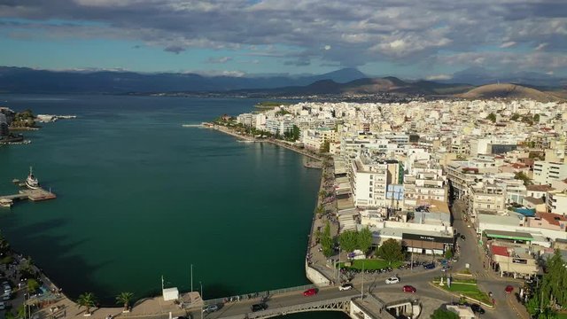 Aerial drone video of iconic town of Halkida or Chalkida with famous old bridge connecting Evoia island with mainland and beautiful clouds, Greece