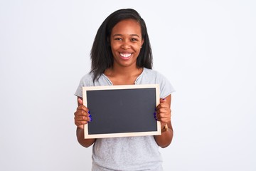 Young african american woman holding blank school blackboard over isolated background with a happy face standing and smiling with a confident smile showing teeth