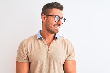 Young handsome man wearing glasses over isolated background looking away to side with smile on face, natural expression. Laughing confident.