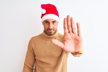 Young handsome man wearing christmas and turtleneck sweater over isolated background doing stop...