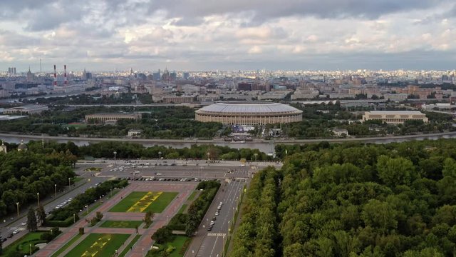 Drone aerial shoot fly over zoom in of stadium Luzhniki and green park with river in Moscow. Sport stadium Luzhniki aerial shot view in summer