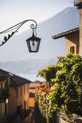 Old metal forged lantern on cozy european street. Old city architecture details.Summer in Italy.