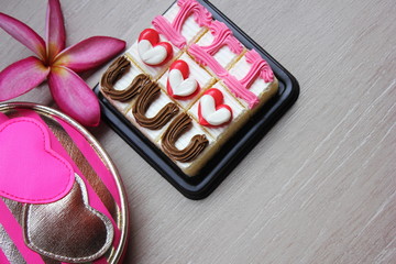 Cakes with the design -I love you-, frangipani flower and cosmetic bag with hearts on it.