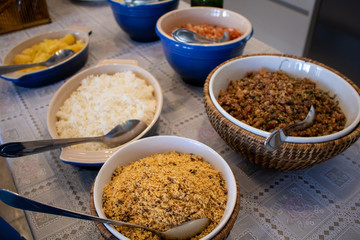 typical brazilian food, rice, beans (feijão tropeiro), farofa, vinaigrette, cooked cassava