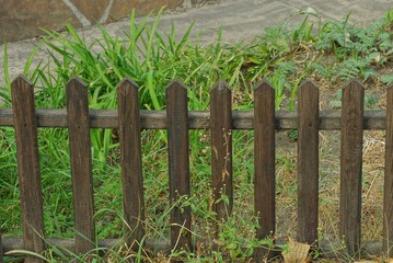 Naklejka premium small brown decorative wooden fence in tall grass