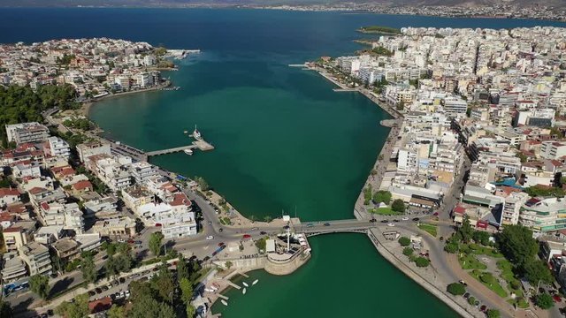 Aerial drone video of iconic town of Halkida or Chalkida with famous old bridge connecting Evoia island with mainland and beautiful clouds, Greece