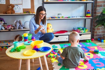 Young therapist woman speaking with child, counselor and behaviour correction at the office around toys