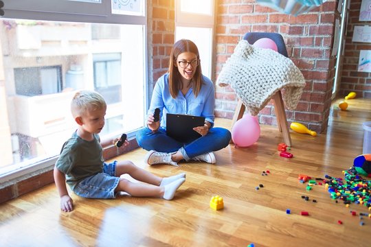 Young therapist woman speaking with child, counselor and behaviour correction at the office around toys