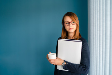 Portrait of young business woman with glasses secretary holding file folder job application in...