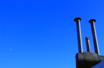Three old chimneys against clear blue sky