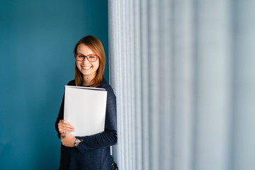 Portrait of young business woman with glasses secretary holding file folder job application in...