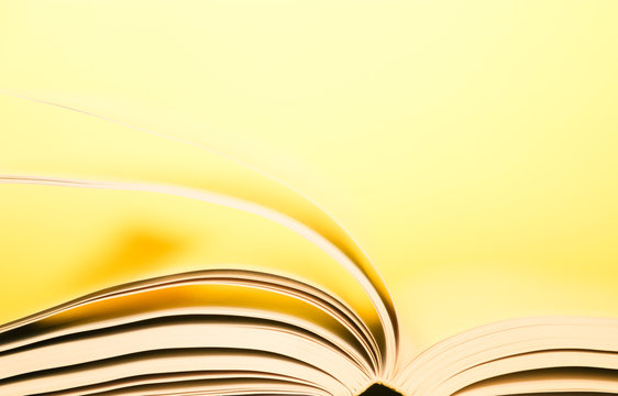 Book pages turning over yellow background. Pages flipping over. 