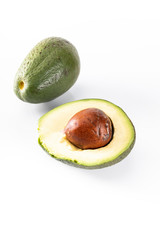 Two ripe avocados. Whole avocado fruit and cut in two.