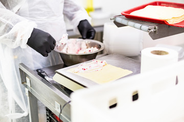 Food factory. The chef wraps pancakes stuffed with cheese and fruit.