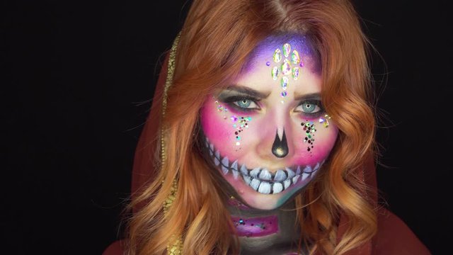 dia de los muertos, pretty girl with pink make-up of sweet sugar skull, creative halloween image, lady with shiny tear of swarovski rhinestones, preparation for latin mexican festival of dead